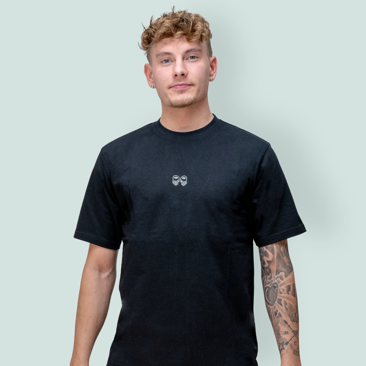 En ung mann poserer med sort t-skjorte